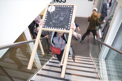 A player runs up some stairs carrying a blackboard.